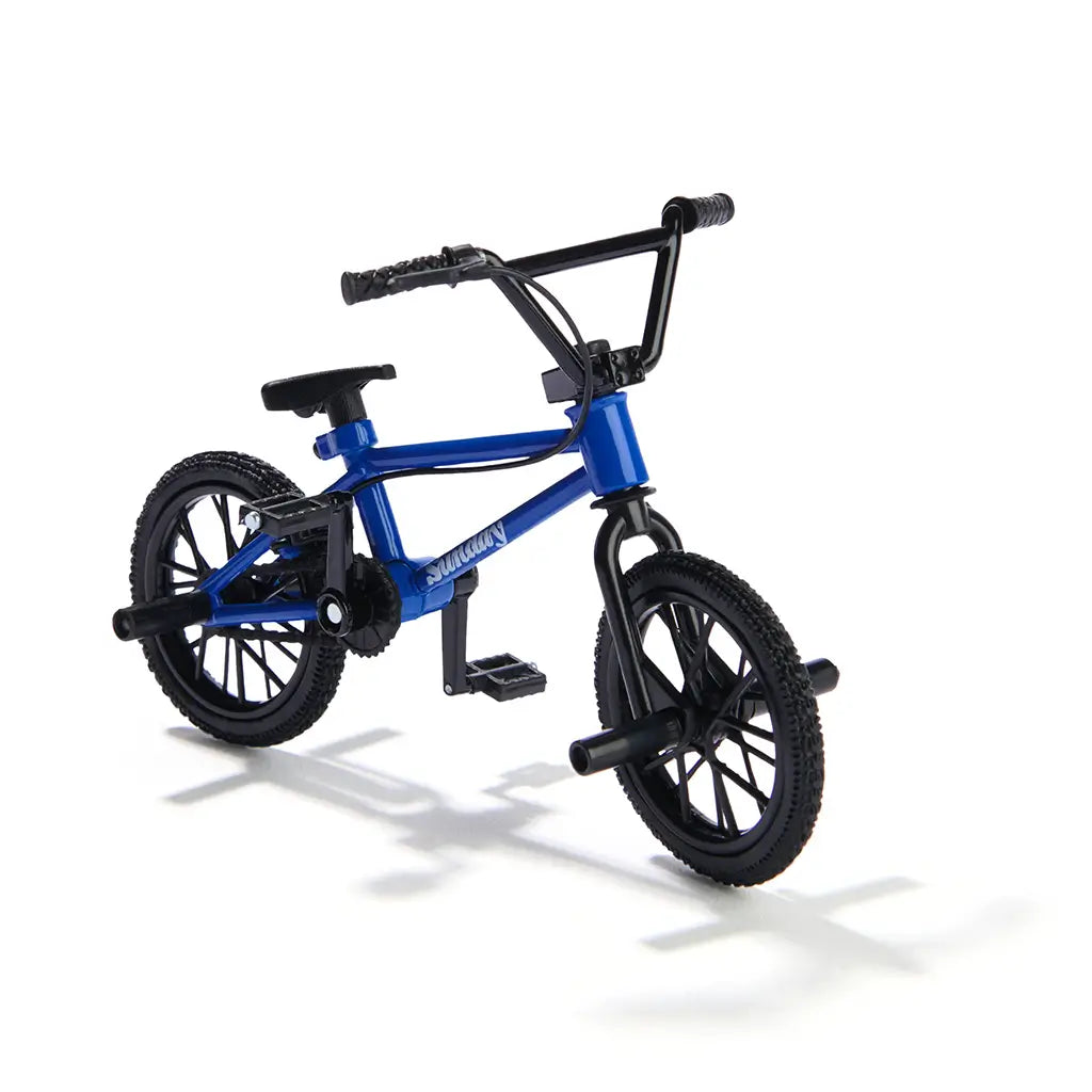 Tech Deck BMX finger bike in blue metal frame with black rubber tires, compact freestyle stunt bike form with pegs, pedals, and handlebars, displayed on a clean white background.