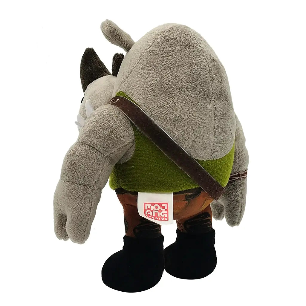 Rear angled view of Rocksteady plush figure from Teenage Mutant Ninja Turtles, gray rhino in green vest and camo pants, with fabric tag visible on back seam.