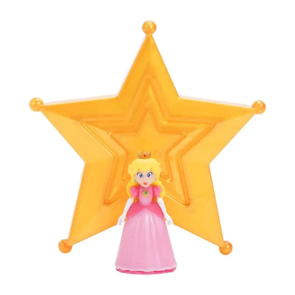Super Mario Galaxy Princess Peach figure front view in pink and gold plastic with flowing dress and crown, upright elegant form positioned before translucent orange star backdrop on a plain white background