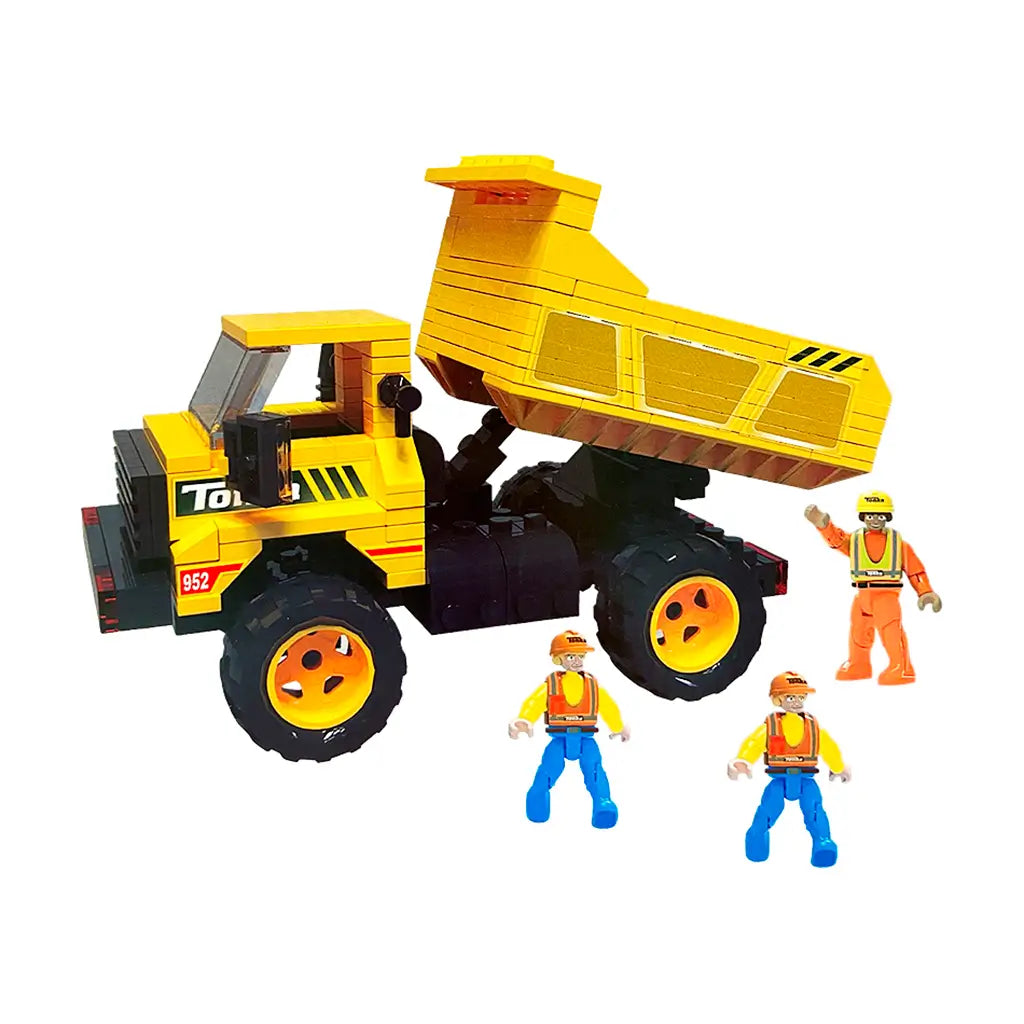 Tonka yellow plastic dump truck toy with tilting bed, black tires, and orange hubcaps, surrounded by three construction worker figures in helmets and safety vests on a white background.