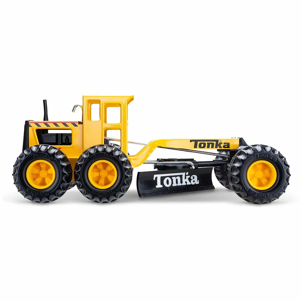 Side profile of yellow and black Tonka grader toy featuring large rubber wheels and adjustable front blade on white background.