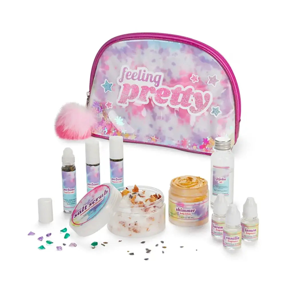 Toy Box “Feeling Pretty” spa craft kit with shimmering pink and purple pouch, small bottles of essential oils, shimmer lotion, and salt scrub ingredients arranged for a fun DIY beauty project.