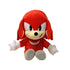 Sonic Knuckles plush toy in bright red soft fabric with rounded cartoon shape, featuring stitched eyes, cream muzzle, white gloves and multicolor shoes, designed as a collectible character doll on a white background.