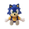 Sonic the Hedgehog plush toy in blue soft fabric with rounded cartoon shape, featuring green eyes, tan muzzle and belly, white gloves and red shoes, displayed on a plain white background.