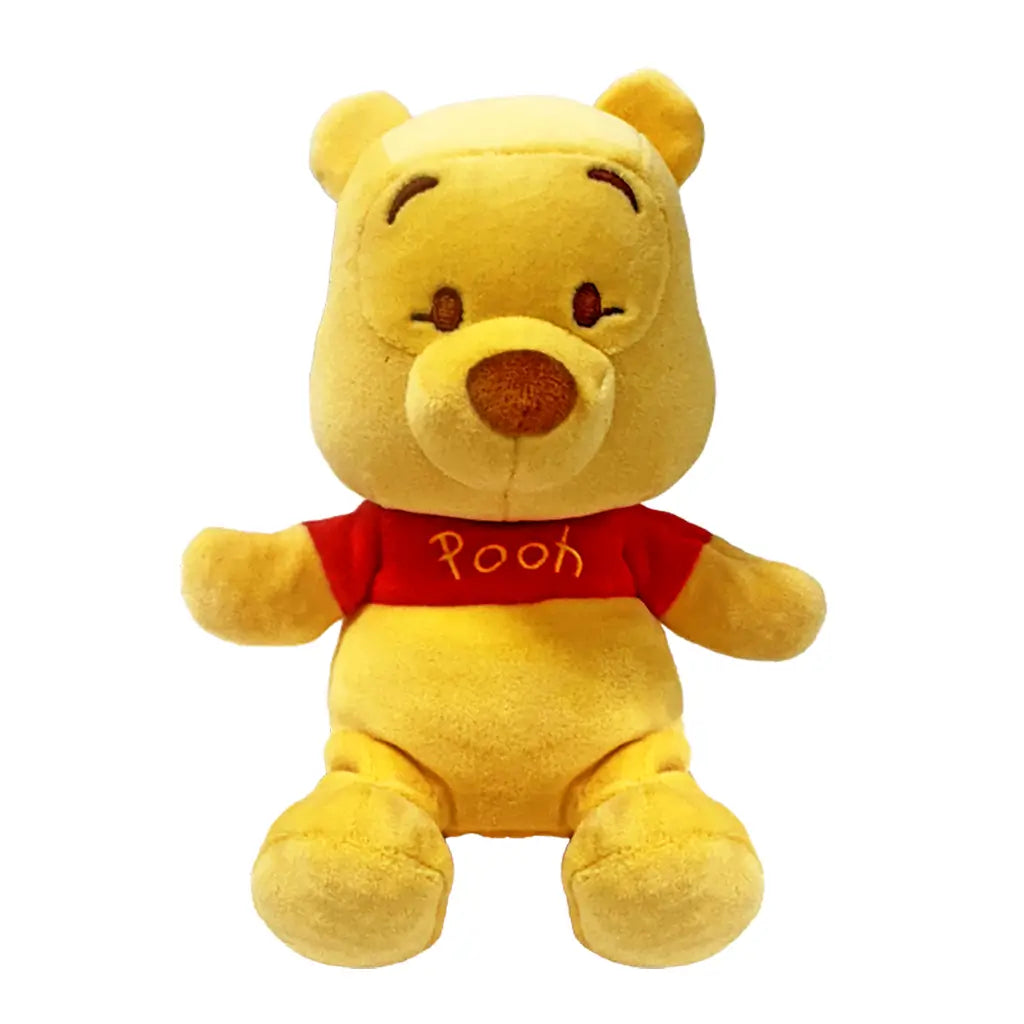 Disney Winnie the Pooh plush toy in soft golden yellow fabric with rounded bear shape, featuring a red shirt labeled Pooh, small ears, embroidered eyes and nose, displayed on a plain white background.