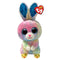 Ty Beanie Boos Twitches rabbit plush toy in pastel multicolor fuzzy fabric with rounded soft body shape, featuring large blue glitter eyes, pink nose, long upright ears with blue glitter lining, and small yellow chick-themed feet on a white background.