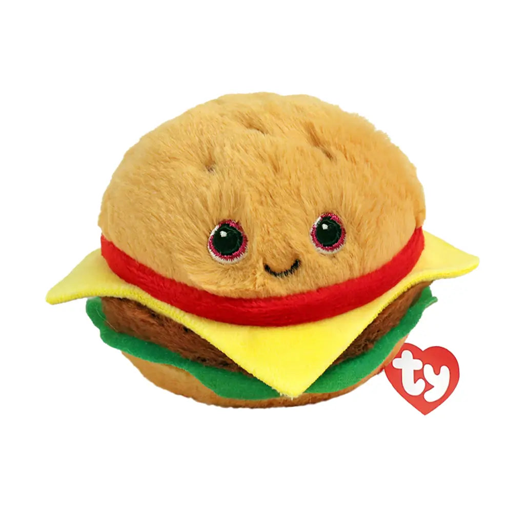 TY Beanie Bouncers hamburger plush toy, tan fuzzy bun with soft texture and layered cheese, lettuce, and filling, rounded bouncer shape with embroidered eyes and smile on a light background.