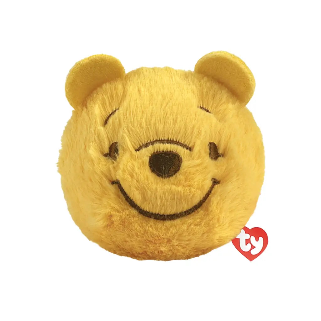 Disney Winnie the Pooh bear plush toy in golden yellow soft fuzzy fabric, rounded ball shape, smiling embroidered face with brown eyes and nose, bounceable plush design, isolated on white background