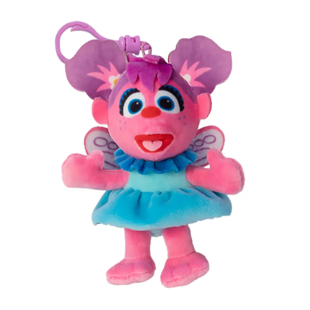 Sesame Street Abby Cadabby plush clip in pink and turquoise soft fabric, with purple pigtails, blue eyes, fairy wings and dress, shown with a pink plastic hook on white.