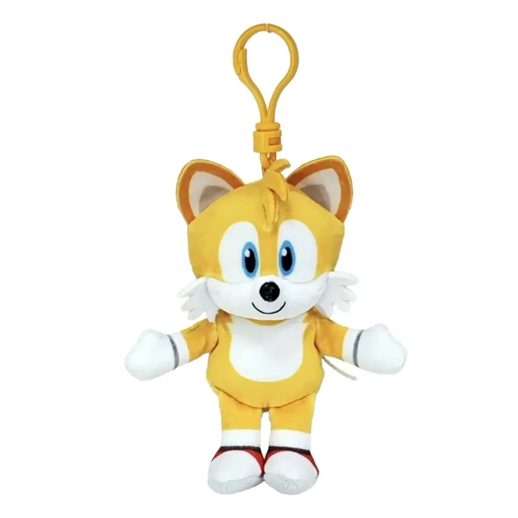 Sonic the Hedgehog Tails plush clip in golden yellow soft fabric, with blue eyes, white muzzle and chest, white gloves and red shoes, hanging from a yellow hook on white.