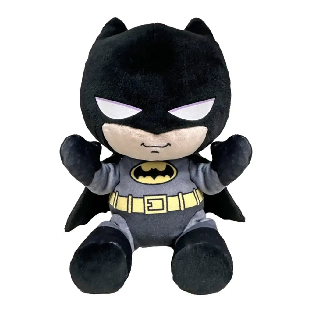 Batman plush toy in black and gray soft fabric, with pointed cowl ears, white eyes, yellow bat emblem and utility belt, seated with raised arms on a plain white background.