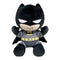 Batman plush toy in black and gray soft fabric, with pointed cowl ears, white eyes, yellow bat emblem and utility belt, seated with raised arms on a plain white background.