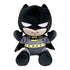 Batman plush toy in black and gray soft fabric, with pointed cowl ears, white eyes, yellow bat emblem and utility belt, seated with raised arms on a plain white background.