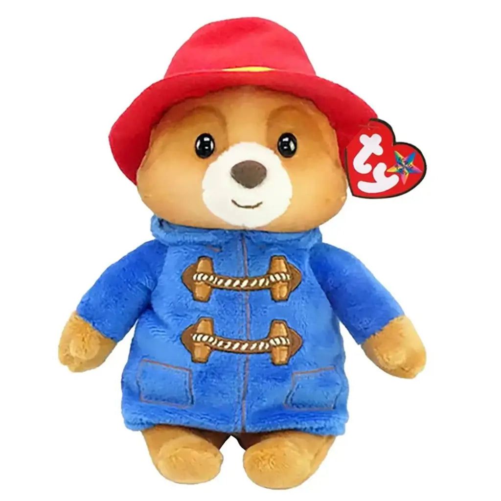 Paddington Bear plush toy Ty Beanie Babies in tan and blue soft fabric, classic bear shape wearing red hat and blue duffle coat with toggle details, friendly character design on white background.