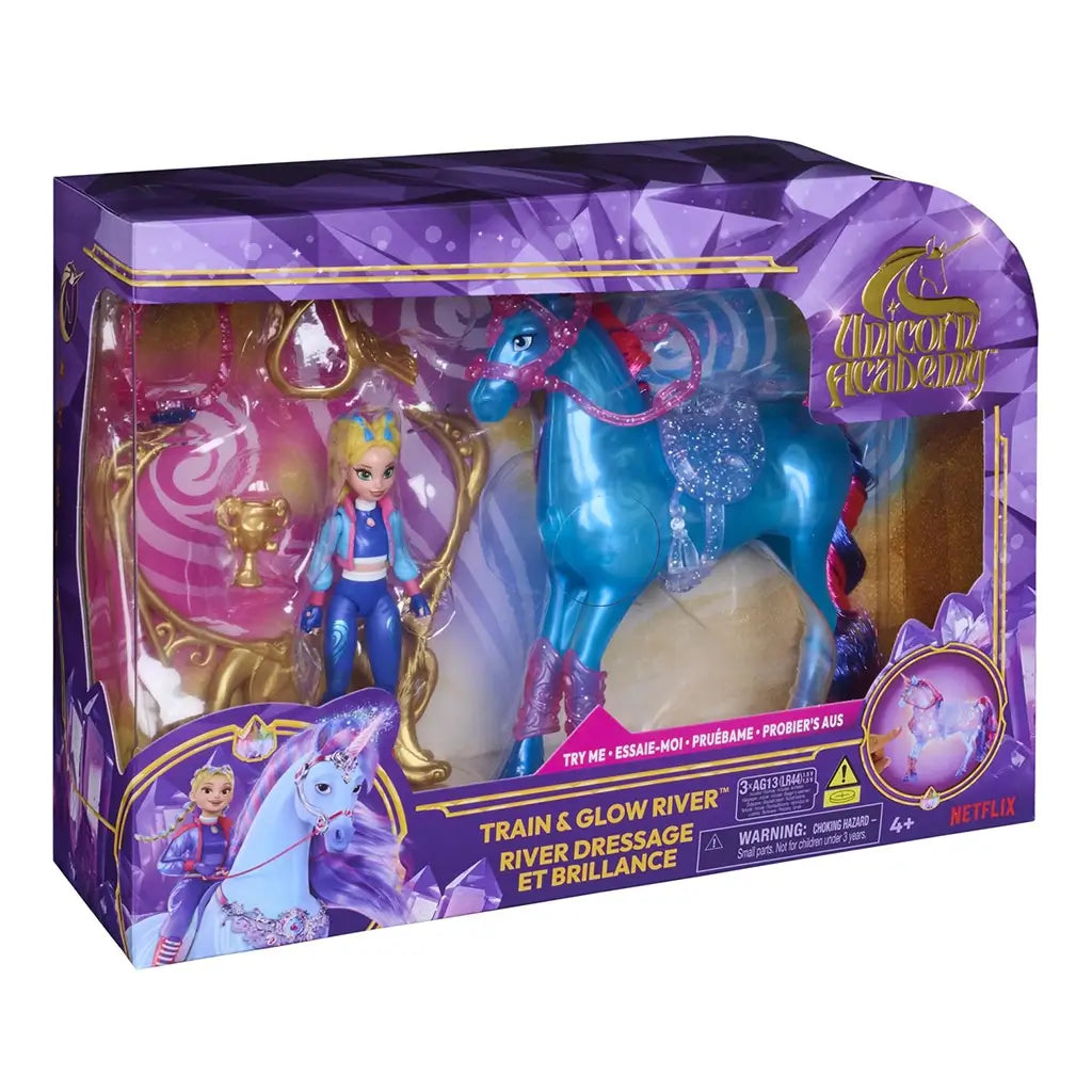 Unicorn Academy River playset package front displaying blue unicorn, blonde rider figure, glowing effects, ornate accessories, and branded purple box design promoting magical light-up play.