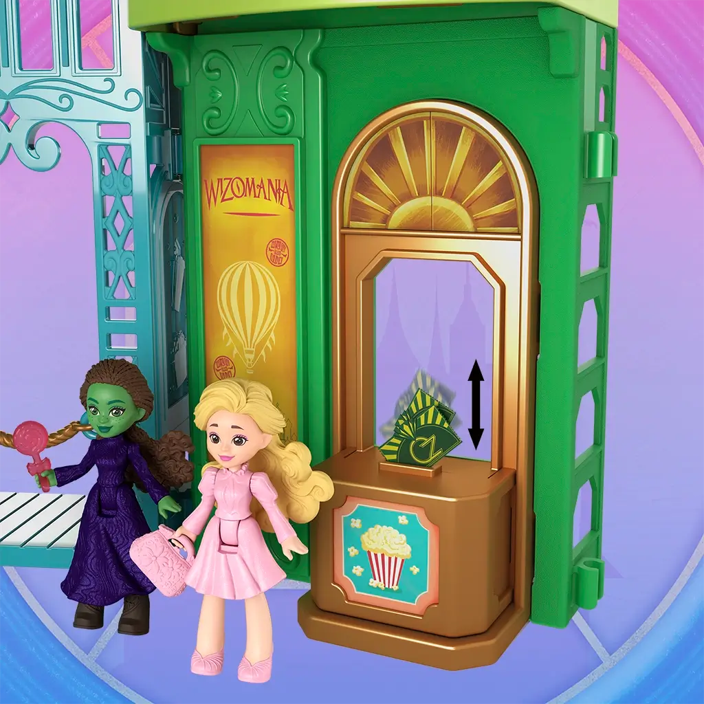 Wicked Emerald City strolling scene showing small dolls seated on a decorative bench before a theatrical Wizomania backdrop, with layered curtains and scenic artwork recreating a magical city experience.
