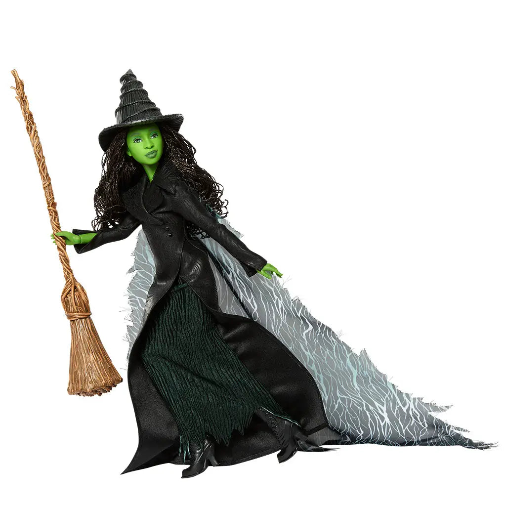 Wicked Elphaba Thropp fashion doll shown in deep black and emerald green colors, featuring textured fabric coat, layered skirt, pointed witch hat, and broom, posed dynamically to highlight articulation, dramatic cape flow, and iconic Wicked character design.