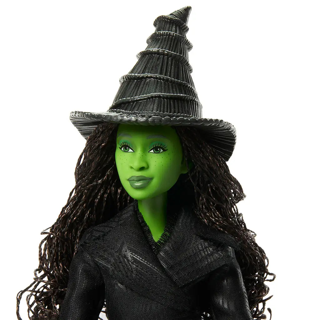 Wicked Elphaba Thropp fashion doll close-up highlights bright green skin tone, smooth vinyl face, long dark textured hair, subtle makeup, and a sculpted black witch hat, emphasizing expressive facial details inspired by the Wicked musical.