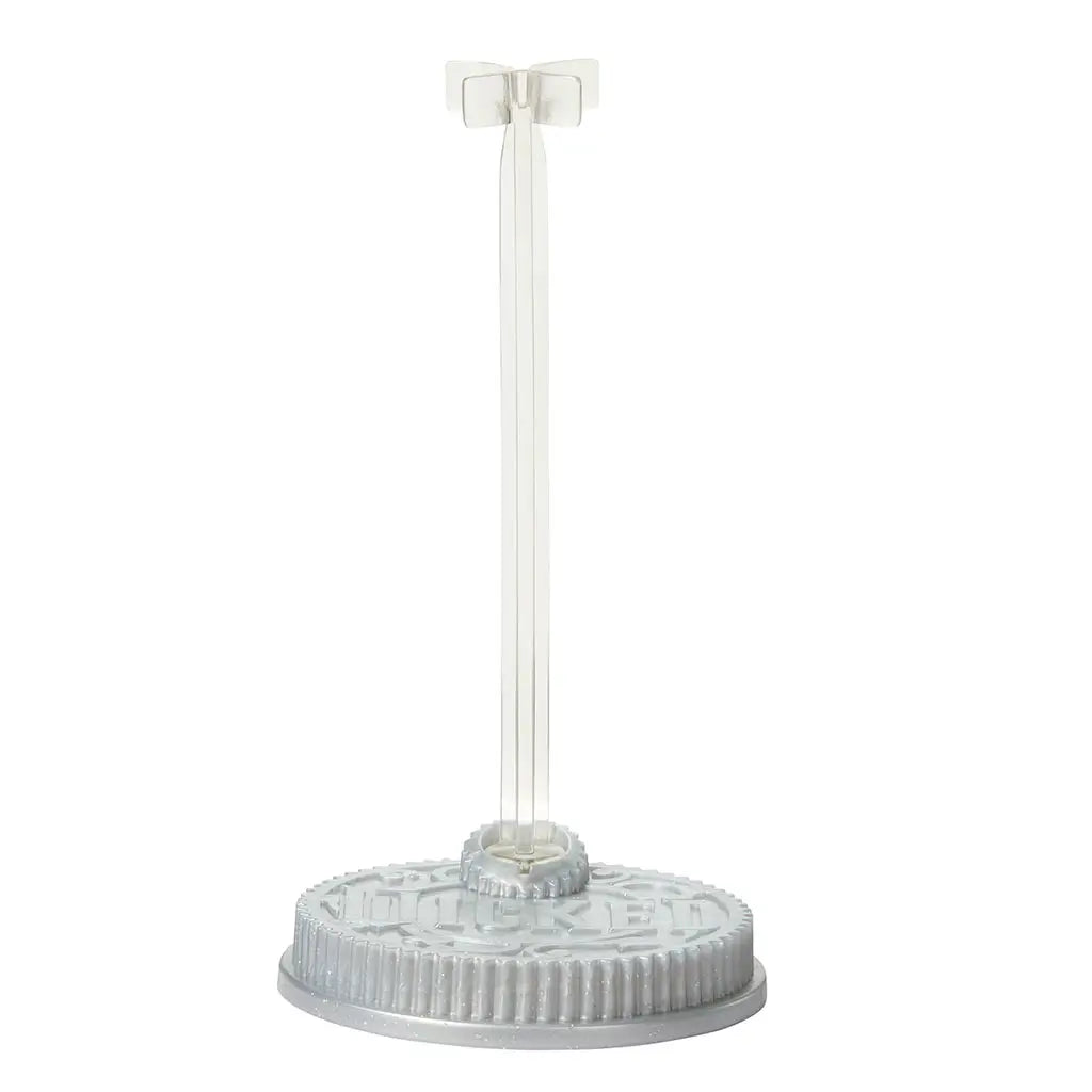 Wicked Elphaba doll display stand shown in clear plastic with round base and vertical support arm, featuring smooth molded texture and stable design intended to hold the Elphaba fashion doll upright for play or display.