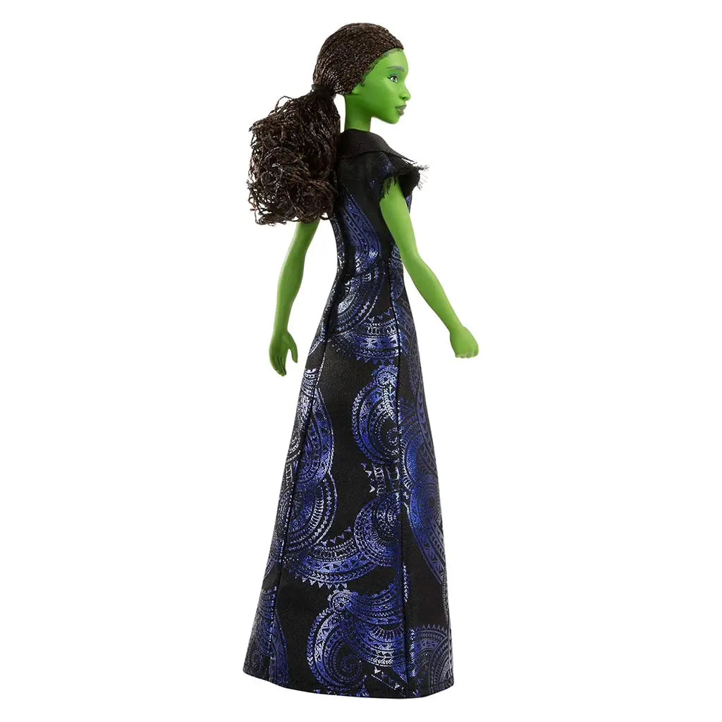 Wicked Elphaba doll side view showing green skin, long dark hair pulled back, flowing black and blue patterned gown, emphasizing silhouette and costume shape against a white studio background.