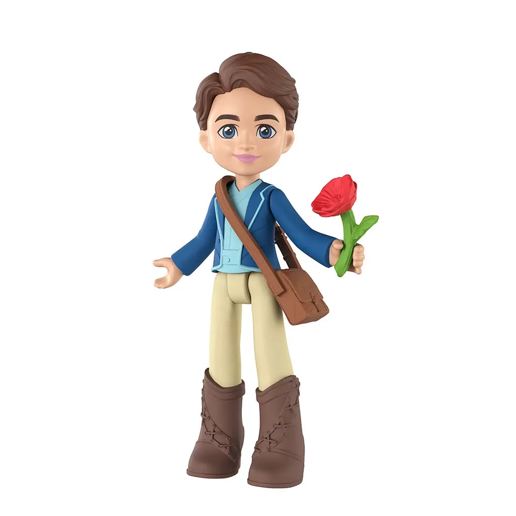 Universal Pictures Wicked doll depicts a blue and tan plastic Fiyero mini figure with brown molded hair, jacket outfit, boots, crossbody satchel, and red flower accessory, standing upright on a white studio background.