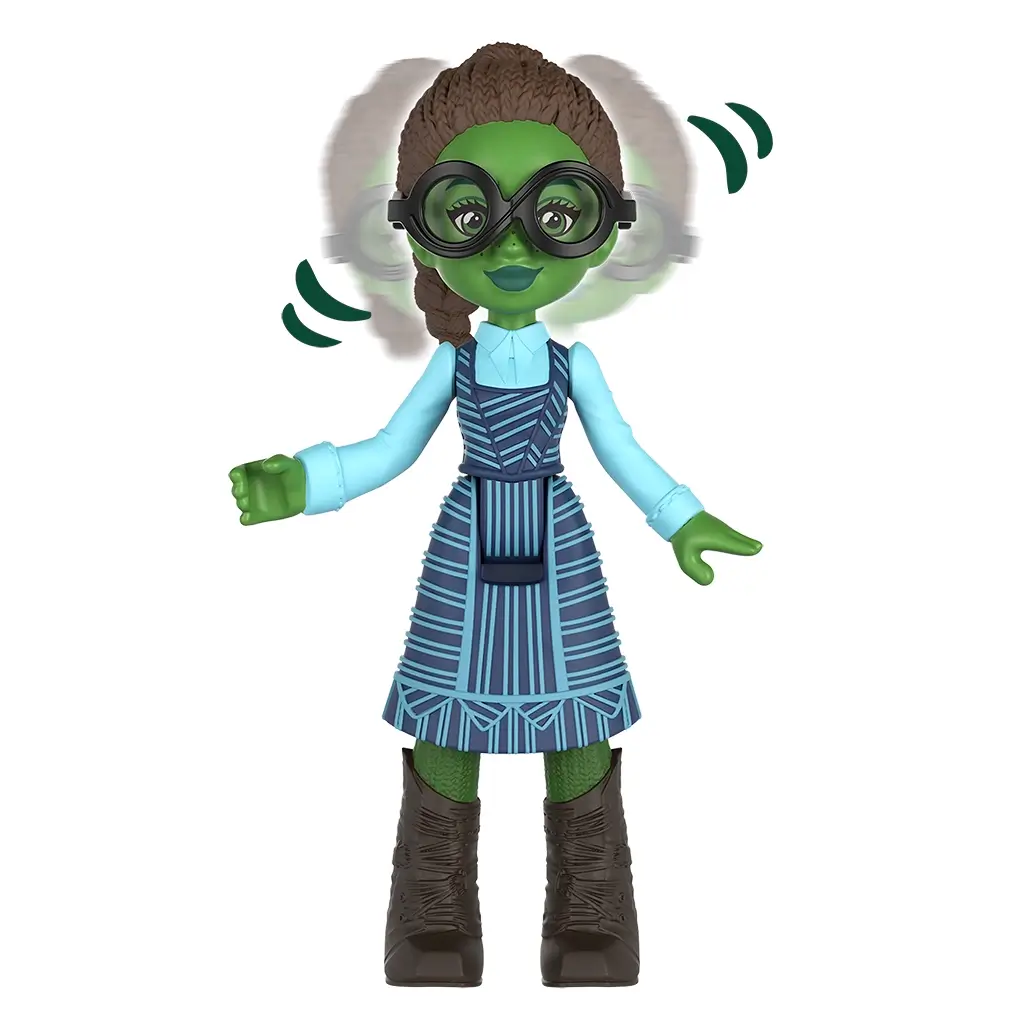 Universal Pictures Wicked mini doll features Elphaba student figure with green skin, braided hair, round goggles, blue patterned dress, boots, and arm articulation illustrated with motion graphics on white background.