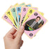 Hand holding a fan of UNO The Office cards showing pastel backgrounds with character photos including Dwight and action cards, styled with paperclip and notebook page themes.