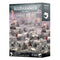 Warhammer 40,000 Genestealer Cults Combat Patrol box displays muted gray industrial cardboard packaging, rectangular in form, showcasing Citadel miniatures for tabletop wargaming, arranged across rubble-strewn sci-fi mining terrain.