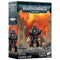 Warhammer 40,000 Iron Hands Caanok Var miniature box, featuring a heavily armored Techmarine-style warrior with bionic limbs and mechanical weapons standing amid ruins and blazing orange skies.
