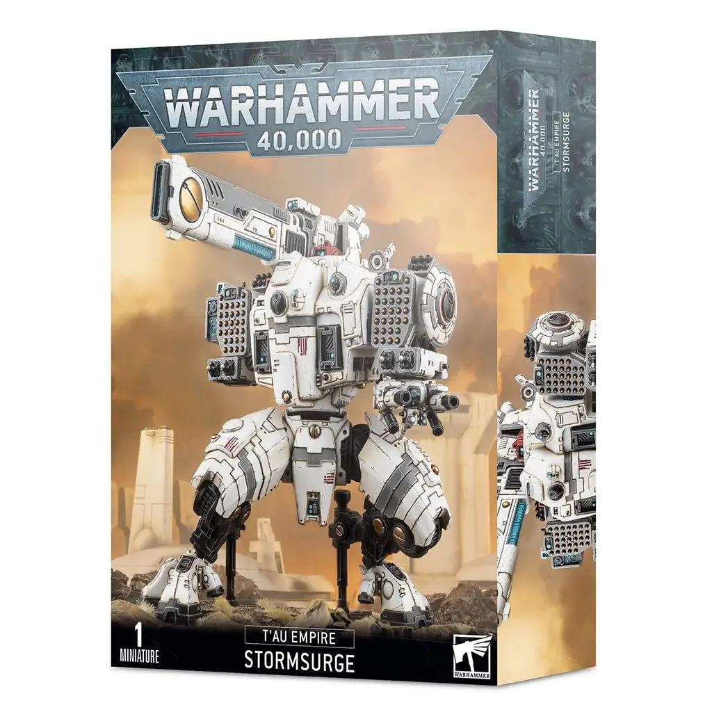Warhammer 40,000 T’au Empire Stormsurge box shows white and gray armored battlesuit artwork on glossy cardboard packaging, rectangular in form, featuring a massive T’au artillery walker miniature for tabletop wargaming, standing on rocky ground within a futuristic battlefield.