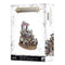 Warhammer Age of Sigmar miniature featuring pale flesh tones with rich purple and gold armor, an ornate grotesque lord seated on a lavish palanquin, representing Glutos Orscollion, Lord of Gluttony, displayed on a distressed white retail box background.