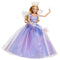 Wicked Glinda deluxe fashion doll shown in lavender and pastel blue colors, with glittered tulle fabric, fitted bodice, flowing ball gown skirt, translucent crown, and star wand, designed as a Mattel collectible inspired by the Wicked musical.