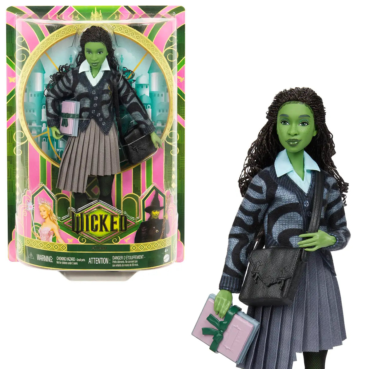 Packaged Wicked Elphaba doll in decorative Wicked box with green and pink design, posed with accessories and backdrop of Shiz University.