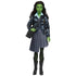 Full front view of Wicked Elphaba doll wearing gray pleated skirt, patterned cardigan, black boots, and black shoulder bag against plain background.