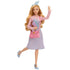 Wicked Glinda doll playfully posed with one leg lifted, holding pink purse and pastel book, wearing light blue heels.