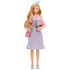 Full-length Wicked Glinda doll wearing light blue chevron dress with pink sheer top, blue heels, and holding pastel book with brown strap.