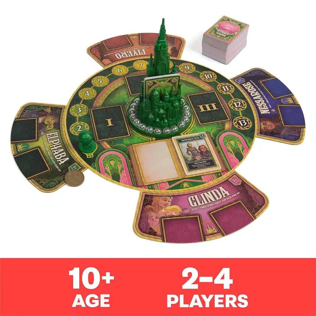 Wicked: The Game board setup with player boards for Glinda, Elphaba, Nessarose, and Fiyero around the 3D Emerald City centerpiece, designed for 2–4 players ages 10 and up.