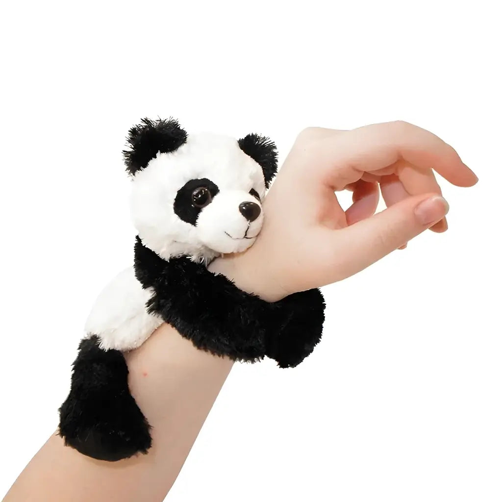 Wild Republic panda plush hugger featuring black and white soft polyester fur, a rounded stuffed body with wraparound arms, designed to cling securely to a child’s wrist against a clean white background.