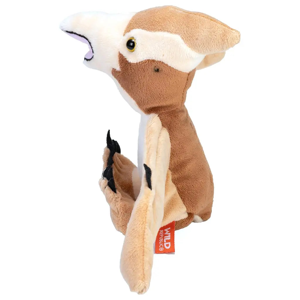 Wild Republic pteranodon plush toy in tan and cream colors with soft fabric texture, upright seated pose showing side profile, folded wings and curved beak, designed as a huggable dinosaur plush for kids or collectors.