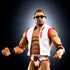 WWE Elite Collection LA Knight wrestling figure close-up showing tan plastic muscular torso, sculpted beard and short brown hair, black sunglasses, white vest with red trim, matching trunks, and confident pose against a dark studio background.
