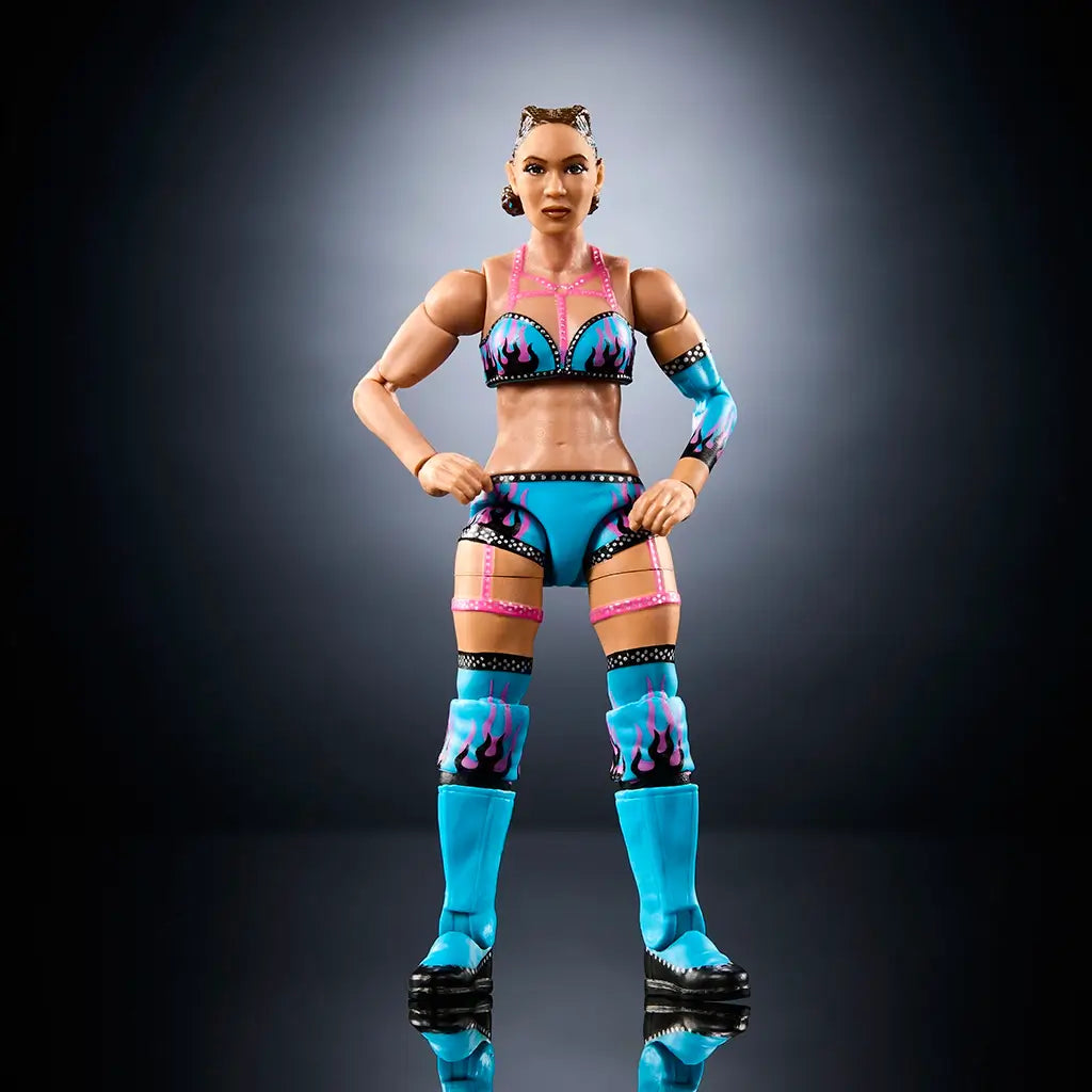 WWE Elite Collection Lola Vice wrestling figure front view displaying turquoise and pink molded plastic gear, athletic body proportions, flame graphics, knee pads, tall boots, articulated joints, and balanced stance on a dark studio background.