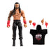 WWE Elite Collection Roman Reigns wrestling figure shown in tan and black plastic with sculpted muscular build, detailed Samoan-style chest and arm tattoos, long molded black hair, red gloves, and black ring pants on a white studio background.