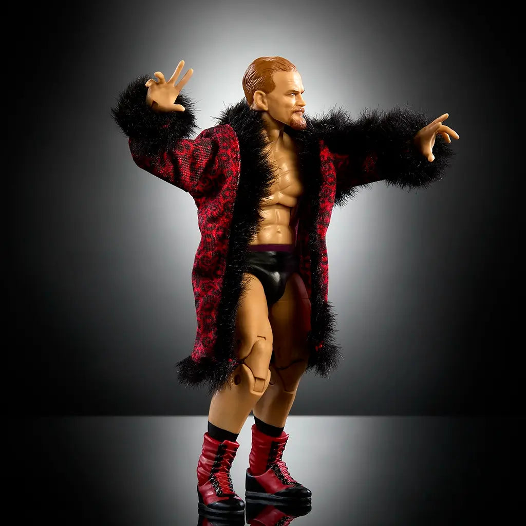 WWE Elite Collection Ilja Dragunov action figure posed dynamically in red robe with black fur trim, demonstrating articulation and detailed sculpting against dark backdrop.