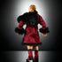 Rear angled view of WWE Elite Collection Ilja Dragunov figure wearing red patterned robe with black fur trim and red lace-up boots, displayed against a dramatic dark background.