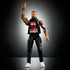WWE Elite Jimmy Uso action figure stands posed with one finger raised, featuring black pants, sleeveless "We The Ones" shirt, white shoes, and detailed sculpting.