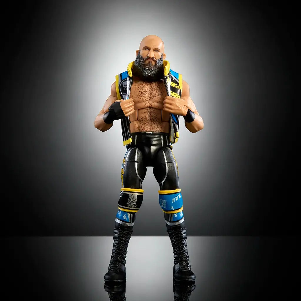 WWE Elite Tommaso Ciampa action figure with black and blue detailed entrance vest, muscular build, and lifelike beard sculpt displayed against a dark gradient background.