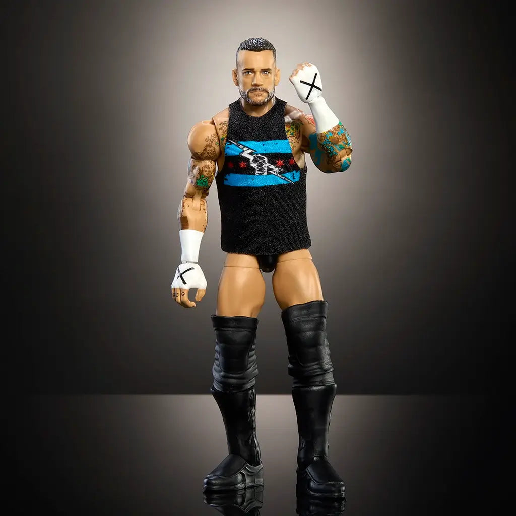 WWE Elite Collection CM Punk figure standing in black vest with Chicago flag logo, fists raised, showing lifelike tattoos and taped hands under spotlight.