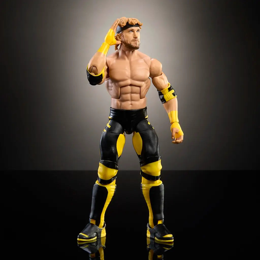 WWE Elite Logan Paul action figure with muscular torso, articulated limbs, and yellow-black wrestling gear, posed with one hand on head under spotlight.