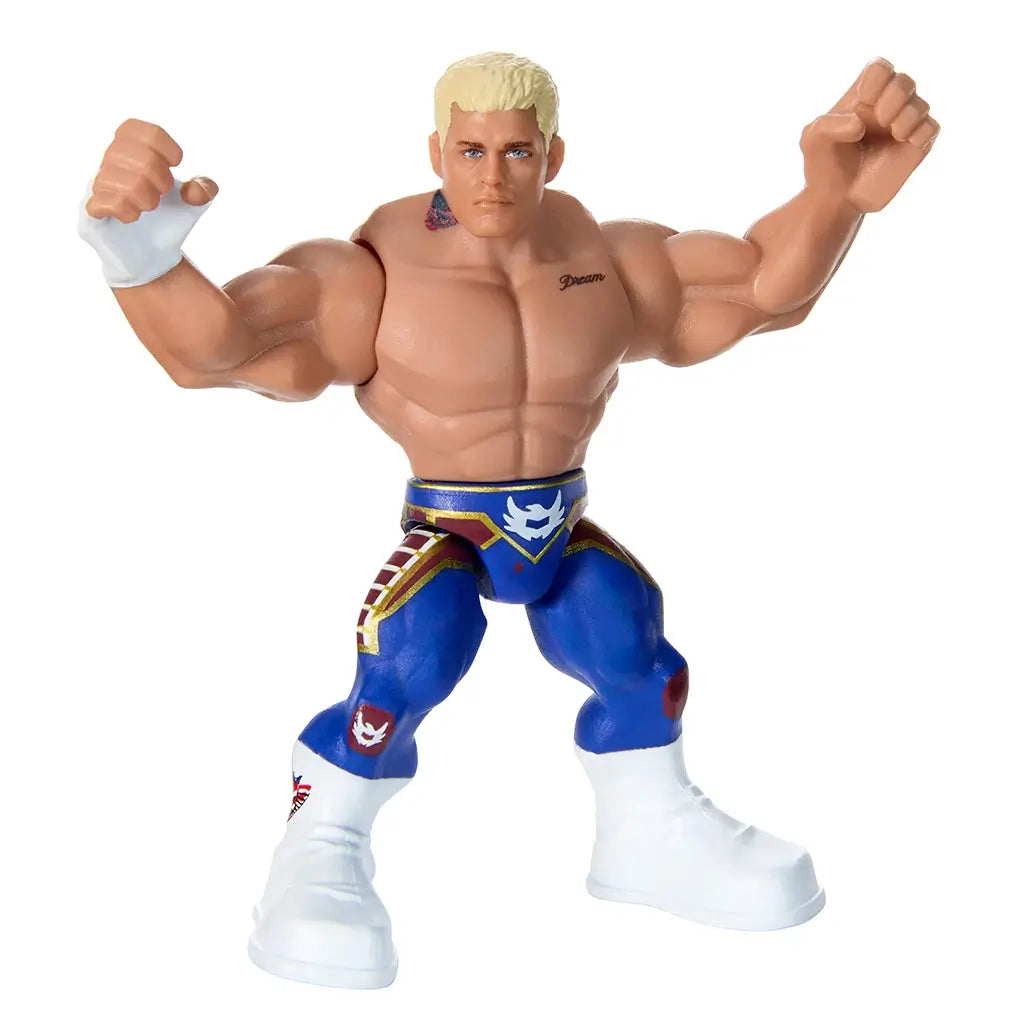 Close-up of WWE Cody Rhodes Knuckle Crunchers figure with detailed muscular body, blue and red tights, white boots, and flexed arms posed for wrestling battle action.