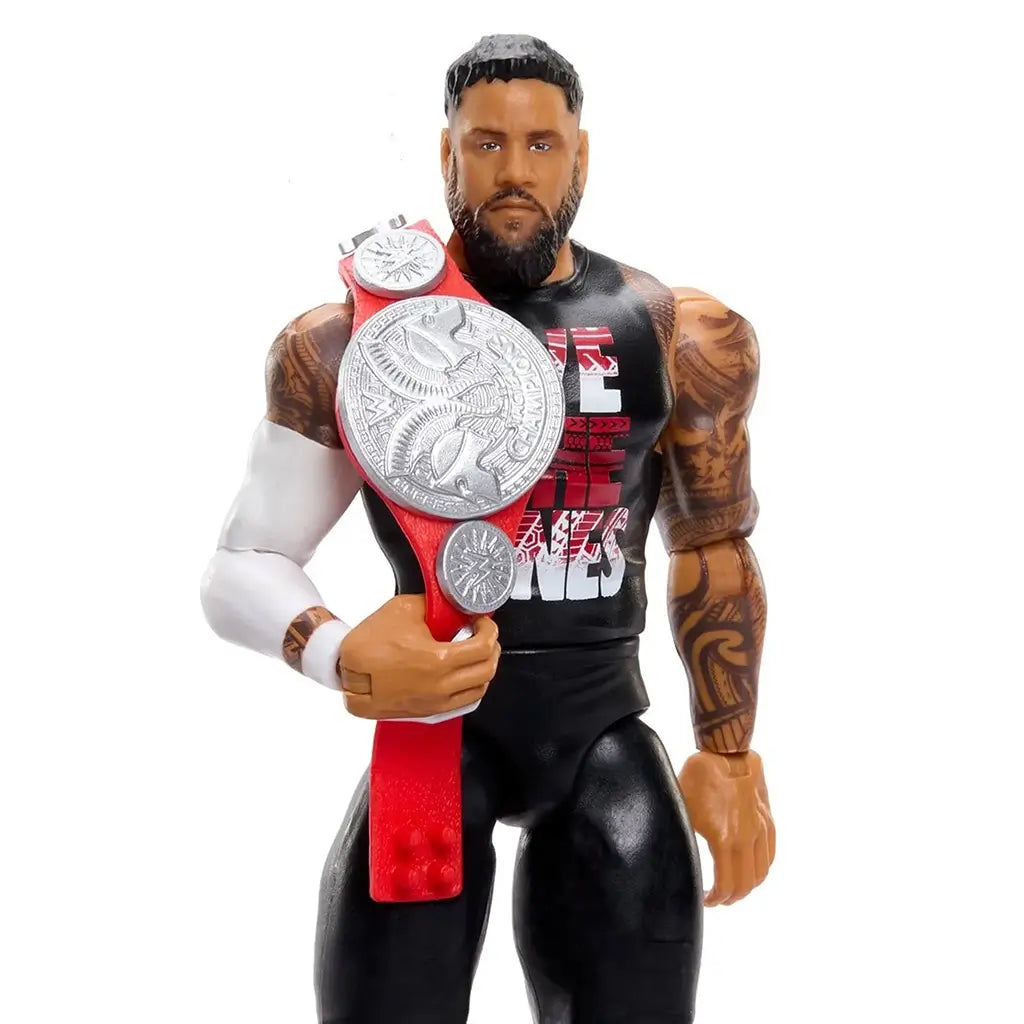 Close-up of the WWE Jey Uso figure holding a silver championship belt, highlighting tattoo detailing, black sleeveless shirt, sculpted facial features, and molded plastic textures in studio lighting.